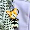 Handmade Corgi and Schnauzer Keyrings displayed as a purse charm on a purple handbag