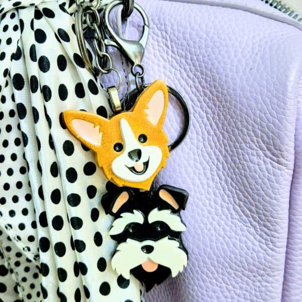 Handmade Corgi and Schnauzer Keyrings displayed as a purse charm on a purple handbag