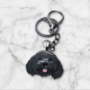 Handmade black cavoodle keychain featuring an adorable curly-haired dog design, crafted from durable resin with a sturdy metal keyring.