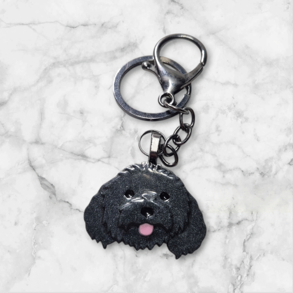 Handmade black cavoodle keychain featuring an adorable curly-haired dog design, crafted from durable resin with a sturdy metal keyring.